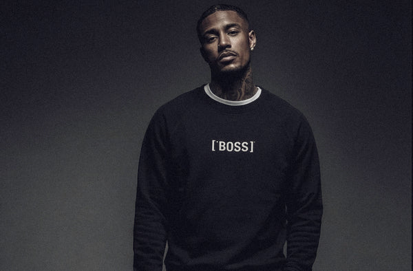 Model wearing ['BOSS]™ sweatshirt in black, clean studio environment