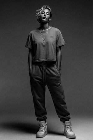 Person wearing a casual outfit with a t-shirt and pants on a plain background