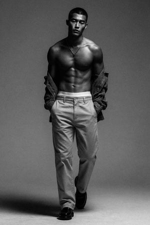 Man wearing a jacket over his shoulders against a plain background