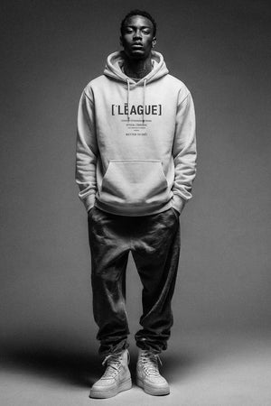 Person wearing a hoodie with 'LEAGUE' branding on a gray background