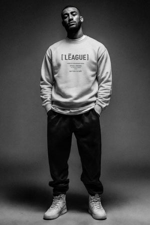Person wearing a gray sweatshirt with text on a dark background